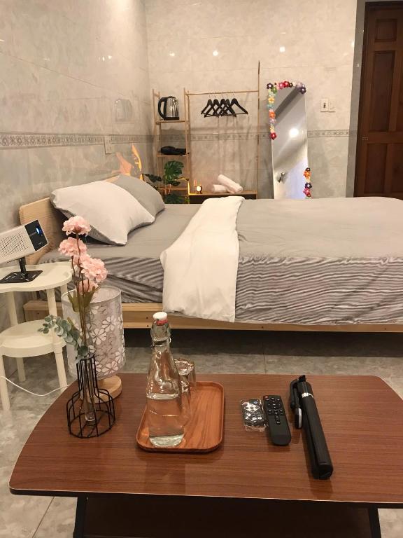 a bedroom with a bed and a table with a remote control at DU Home Huế in Thôn An Hòa