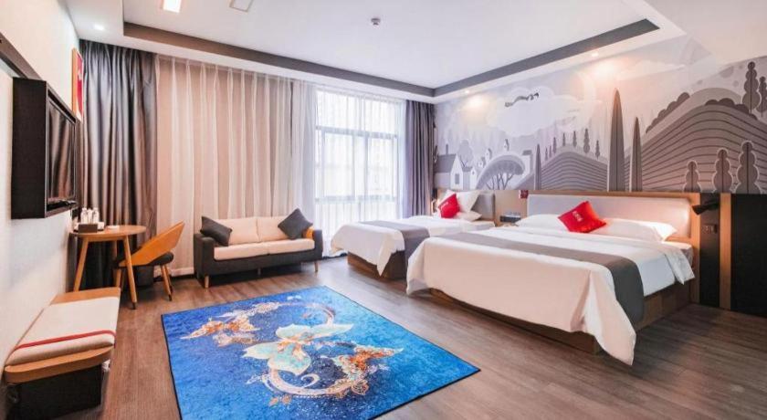 a hotel room with two beds and a blue rug at Thank Inn Guizhou Bijie Qianxi County High-Speed Railway Station in Qianxi