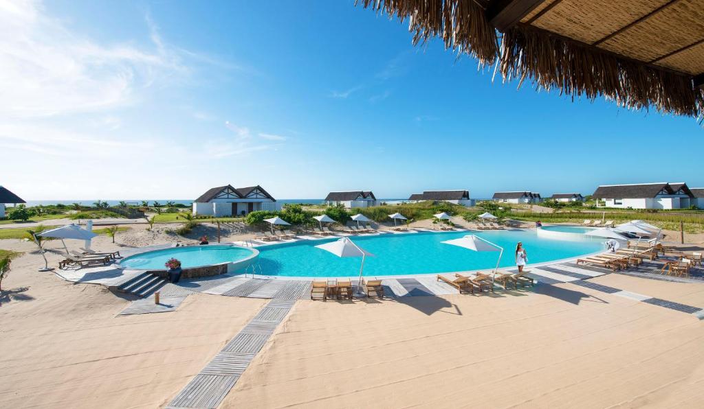 a large swimming pool on the beach with a beach house at Mequfi Beach Resort in Mecúfi