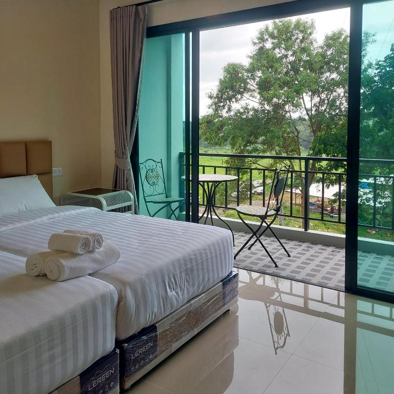 a bedroom with a bed and a balcony with a view at Top Place in Ban Pang Kae