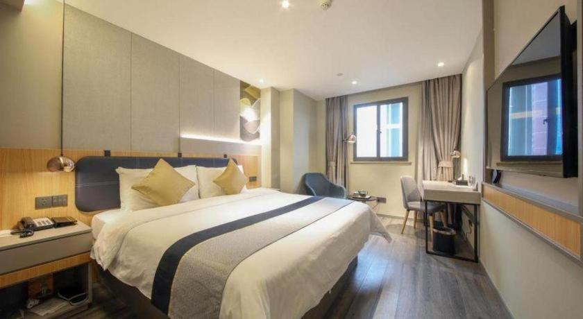 a hotel room with a bed and a desk and a sink at City Comfort Inn Hotel Wuhan Optics Valley Square Metro Station Zhongnan Minzu University in Wuhan