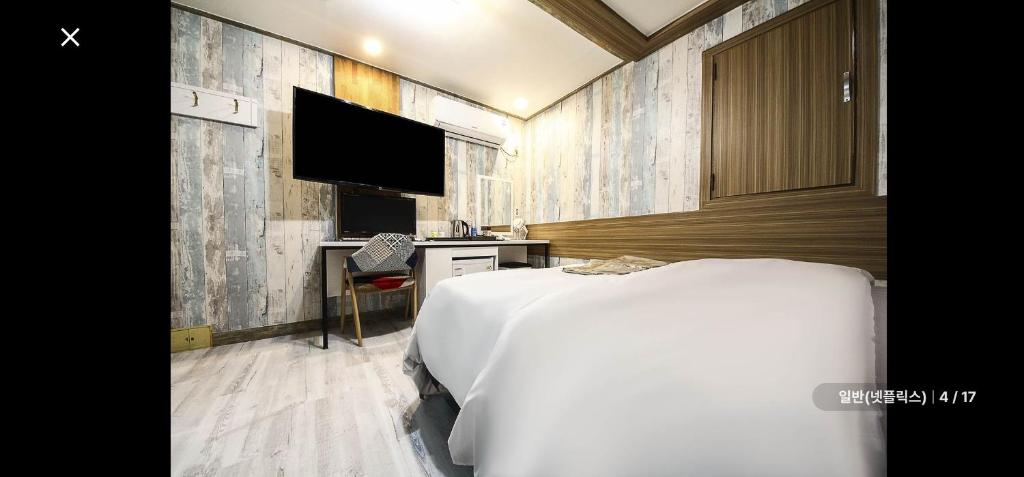 ソウルにあるRamon Hotelのベッドと薄型テレビのある寝室