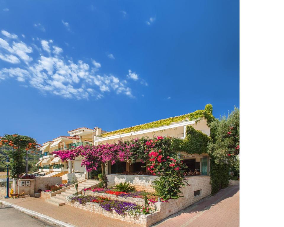 a building with flowers on the side of it at Xenios Loutra Village Beach Hotel in Agia Paraskevi