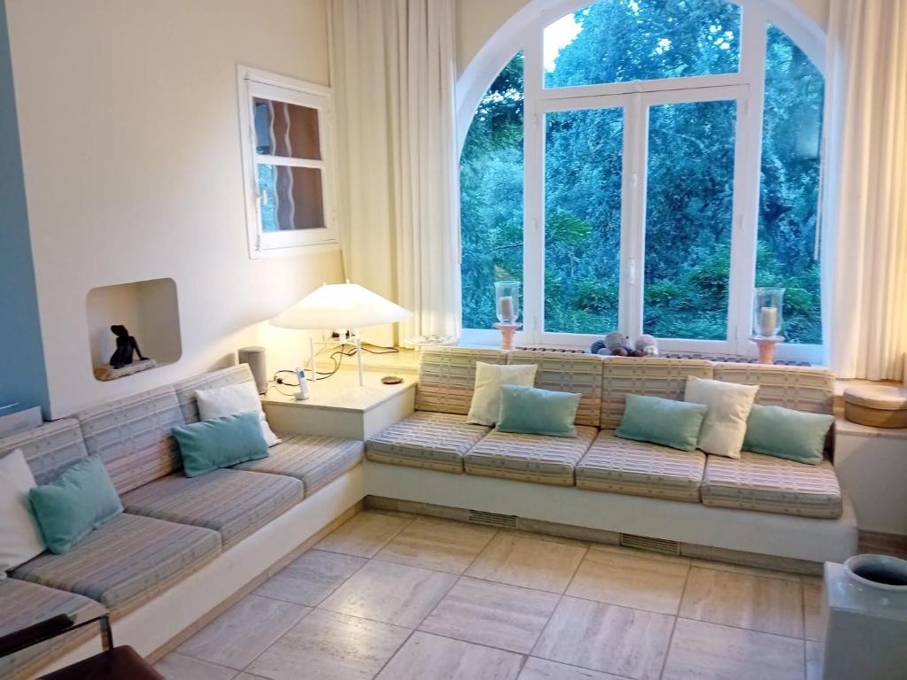 un salon avec un canapé et deux fenêtres dans l'établissement Villa golfe st tropez area & swimming pool, à Grimaud