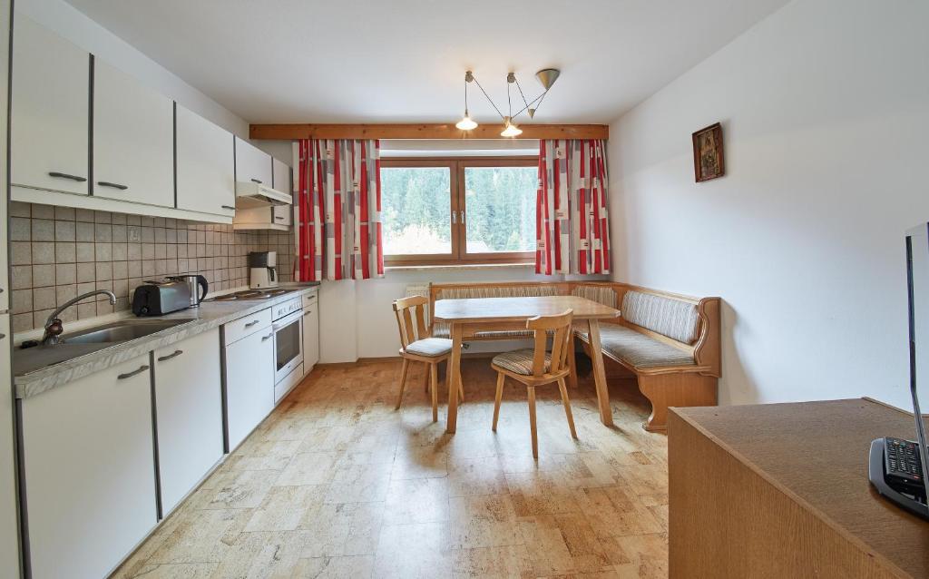 a kitchen with a table and a dining room at Appartements Glemmtal in Saalbach Hinterglemm