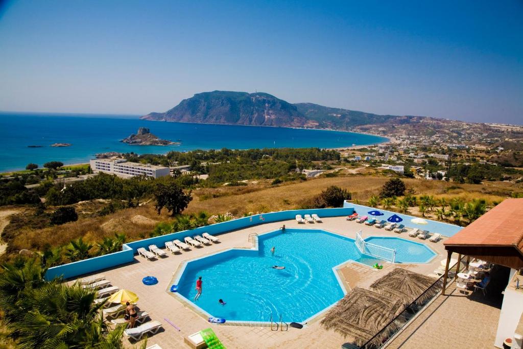 a large swimming pool with a view of the ocean at Pantheon Hotel in Kefalos