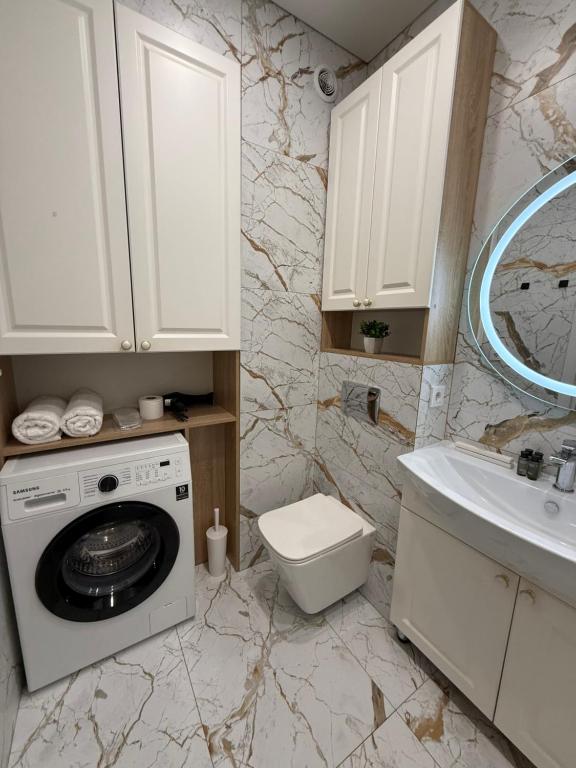 Un baño con lavadora y lavabo. en Сердце Арбата, en Almaty