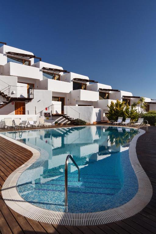 a building with a swimming pool in front of a building at Boutique Hotel El Tio Kiko in Agua Amarga