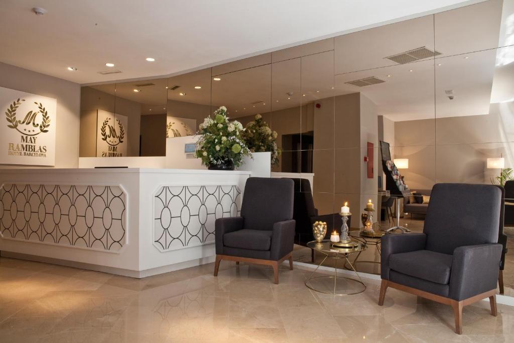 a salon with two chairs and a table and a mirror at May Ramblas Hotel in Barcelona