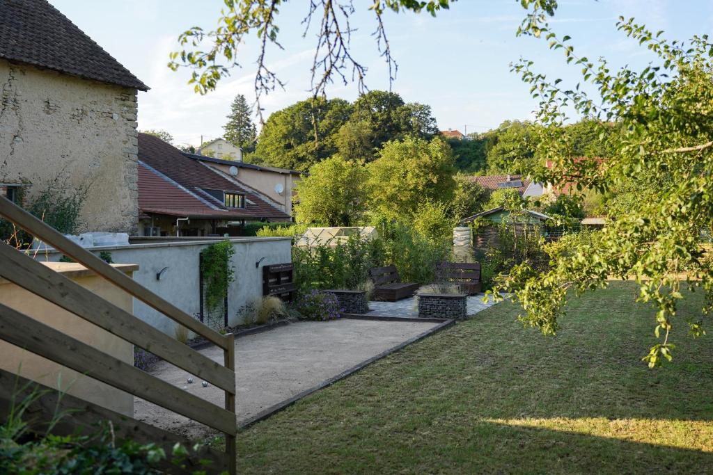 un giardino con patio e una casa di Gite des Campenottes a Longevelle-sur-Doubs