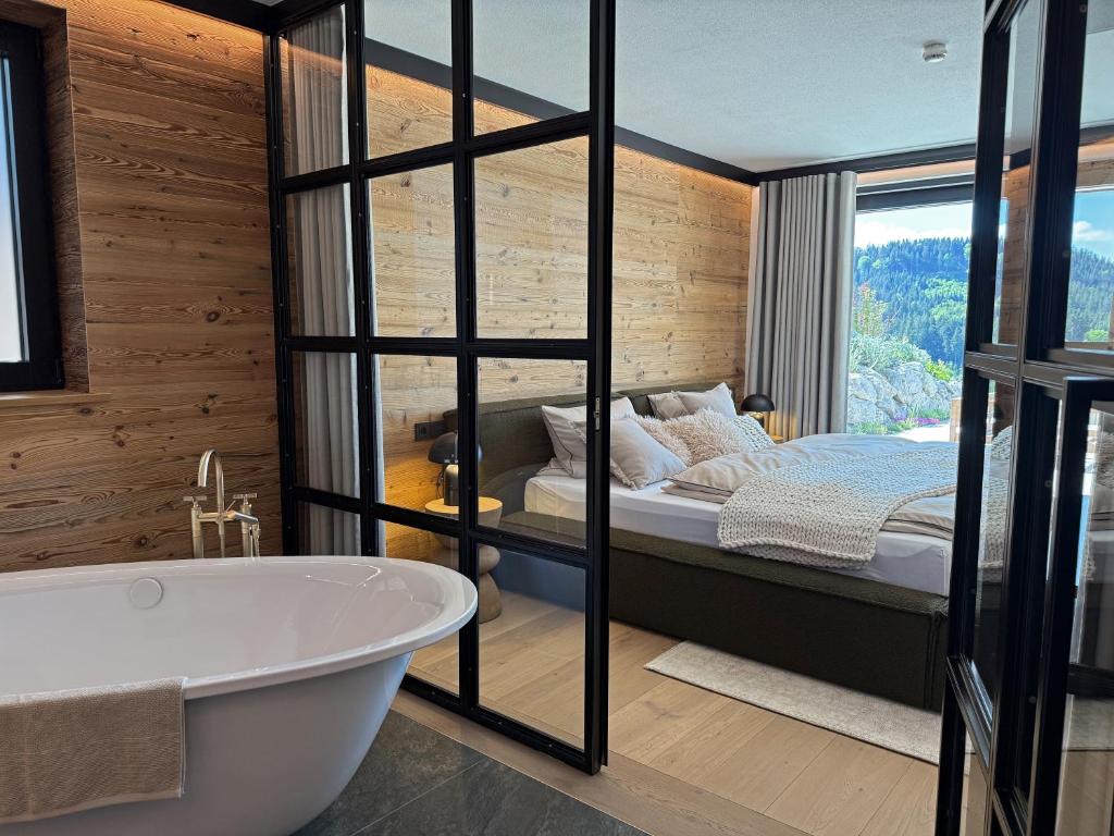 a bathroom with a tub and a bed in a room at Chalet Mädesüss in Weitnau