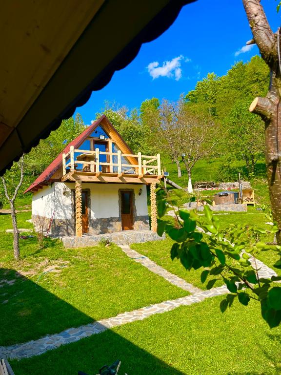 a house with a balcony on top of it at Cabană tip A Wild Glamping Cornereva in Cornereva