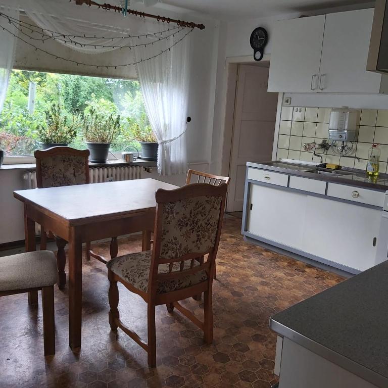 a kitchen with a table and chairs in a kitchen at Eifelhaus in Niederdorla
