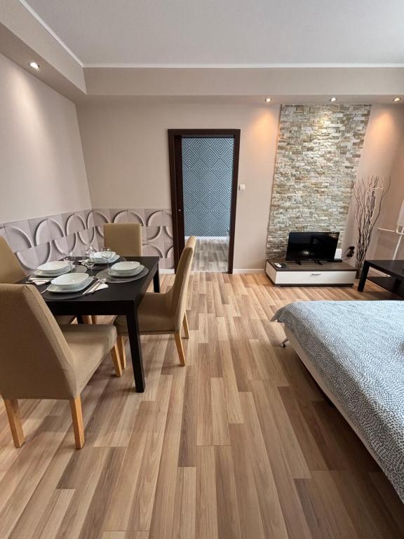 a dining room with a table and chairs and a bedroom at Balian apartman in Siófok