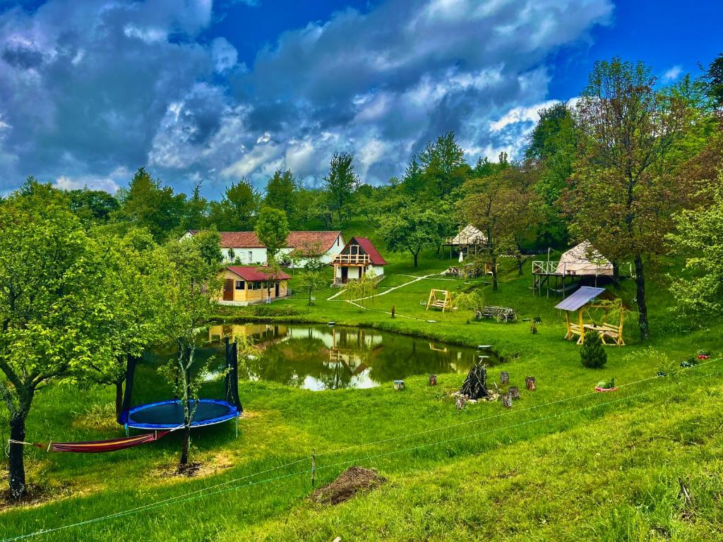 a park with a playground next to a lake at Wild Glamping Cornereva in Cornereva