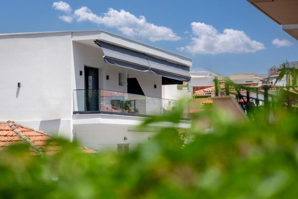 a white house with a balcony with a view at sarti luxury diaMoNd in Sarti