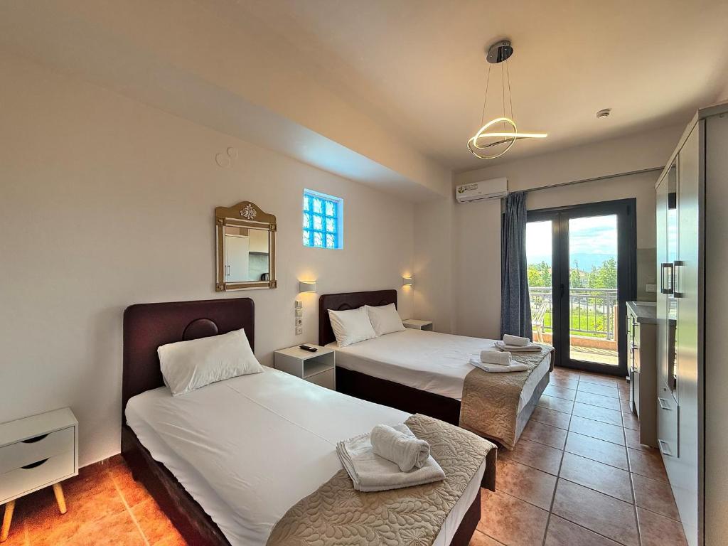 a hotel room with two beds and a balcony at Olympic Studios by SDR in Olympiaki Akti