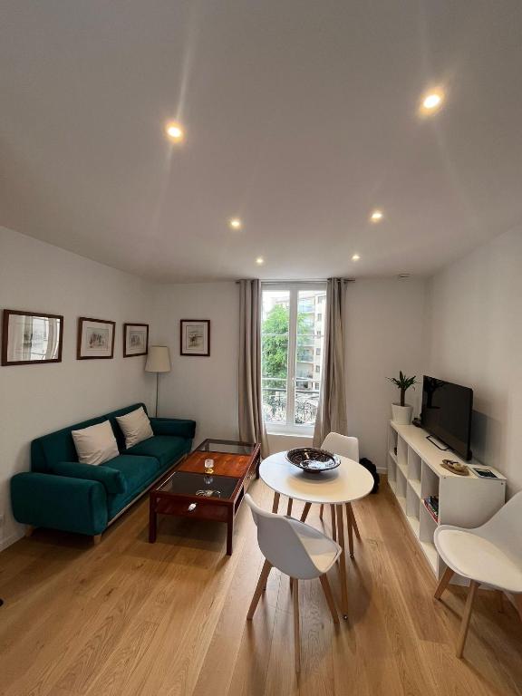 un salon avec un canapé vert et une table dans l'établissement Charmant T2 à Puteaux, à Puteaux