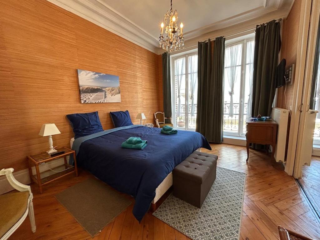 - une chambre avec un lit bleu et un lustre dans l'établissement La Mouette - Superbe romantique cœur de ville, à Trouville-sur-Mer