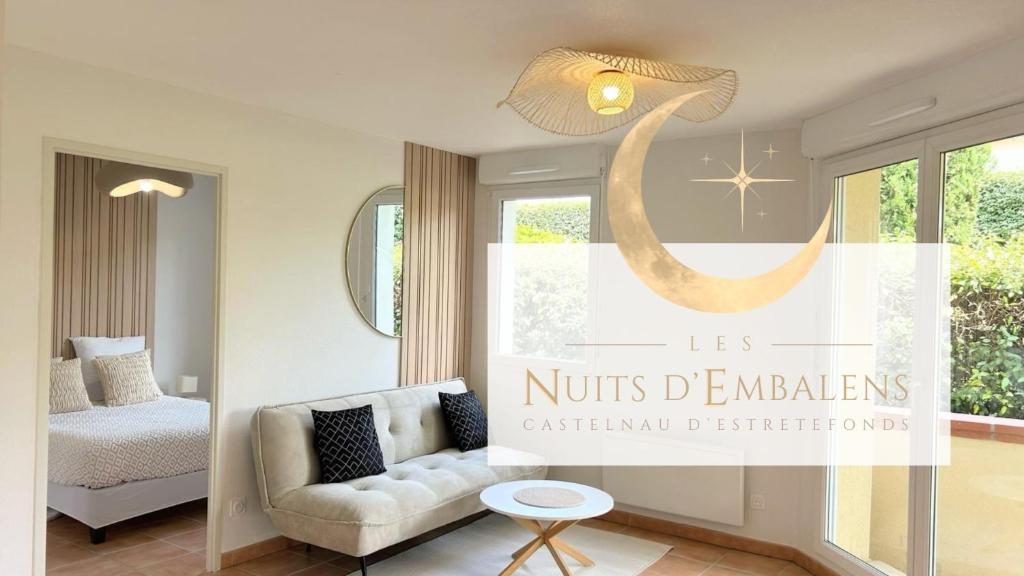 una sala de estar con un sofá y una cama en Les Nuits d'Embalens, en Castelnau-dʼEstrétefonds