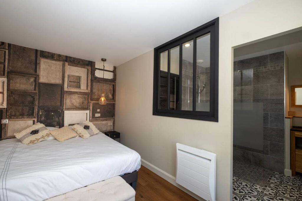 a bedroom with a white bed and a window at MIA in La Noue