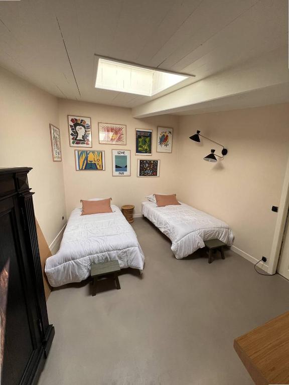 une chambre avec deux lits dans une pièce dans l'établissement Maison de famille en pierre, à La Couarde-sur-Mer