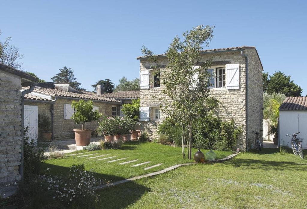 an old stone house with a garden in front of it at Maison de famille en pierre in La Couarde-sur-Mer