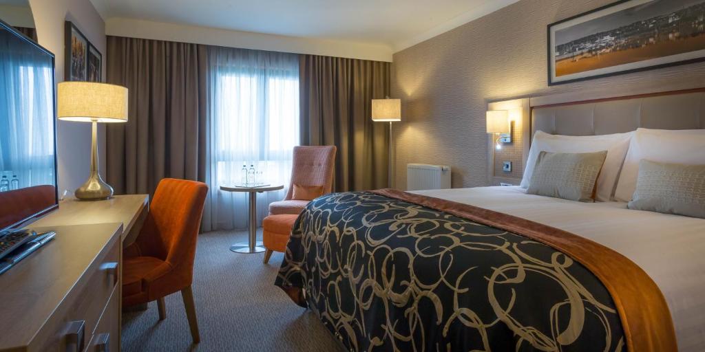 a hotel room with a large bed and a desk at Whites of Wexford in Wexford