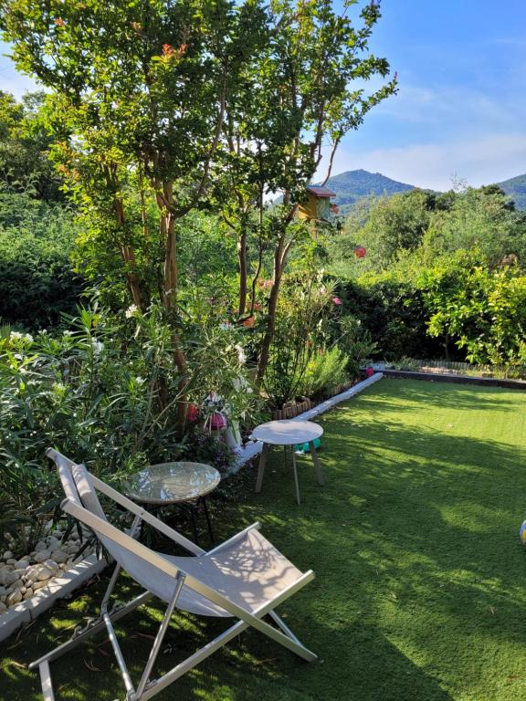 une pelouse avec une chaise et une table dans une cour dans l'établissement Évasion en Côte d'Azur - Mazet Cosy - Restanques, à Grimaud