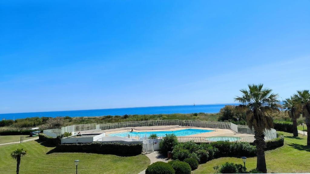 une vue aérienne d'un complexe hôtelier avec piscine et l'océan dans l'établissement St Cyprien T3 lumineux en bord de plage Piscine, à Saint Cyprien Plage
