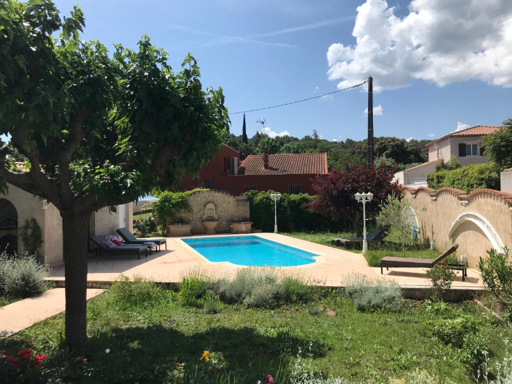 - une piscine dans une cour avec un arbre dans l'établissement Joli rez de villa proche d'Aix-en-Provence, à Peyrolles-en-Provence