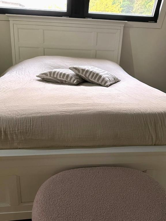 two pillows sitting on top of a bed with a window at Luxe Penthouse nabij Nijmegen in Ubbergen