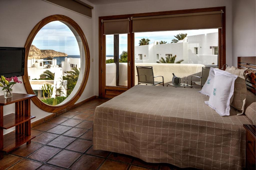 a bedroom with a large bed and a large window at Boutique Hotel El Tio Kiko in Agua Amarga