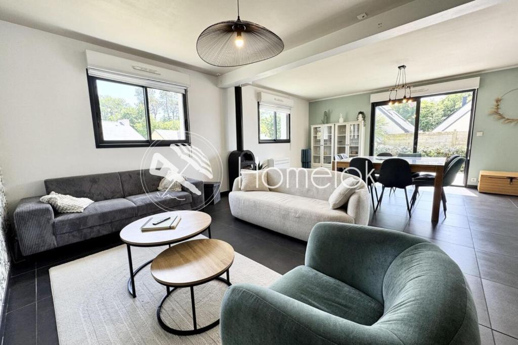 un salon avec deux canapés et une salle à manger dans l'établissement Belle maison contemporaine aux portes de Lorient, à Kervignac