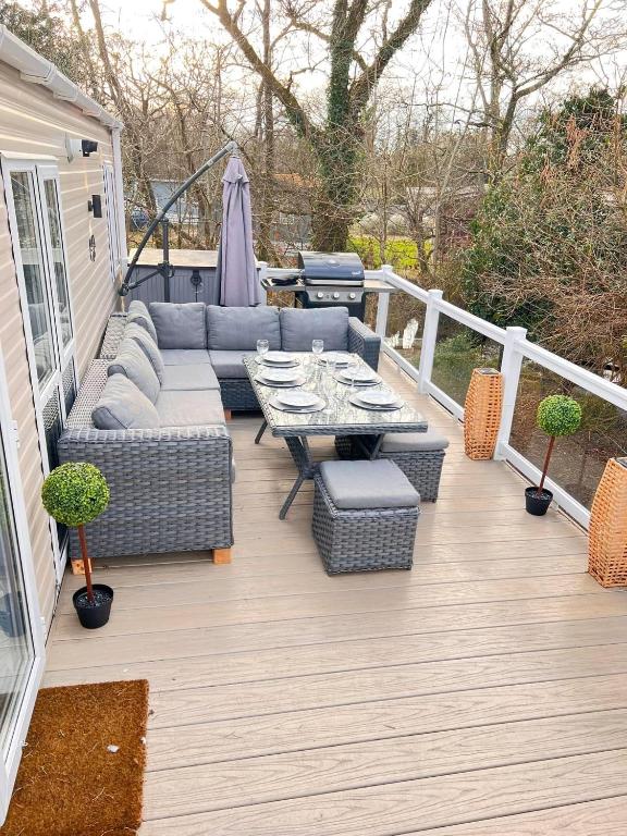 a patio with a couch and a table on a deck at Jasmine Corner - entertainment passes included - message for longer stays in Ringwood
