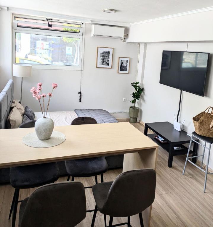 a living room with a table and a tv at Loutraki central studio in Loutraki