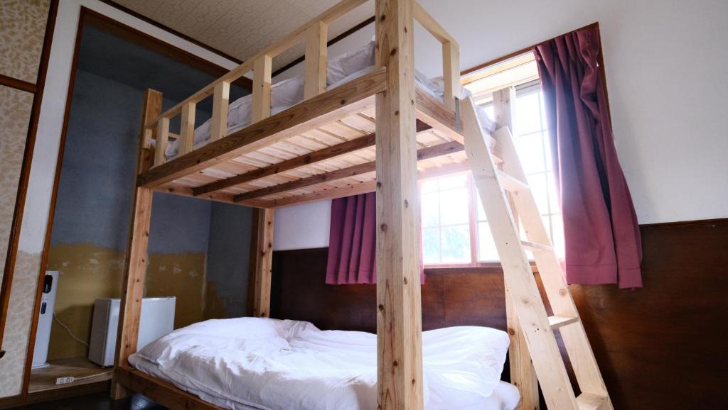 Postel nebo postele na pokoji v ubytování ゲストハウス桜月荘