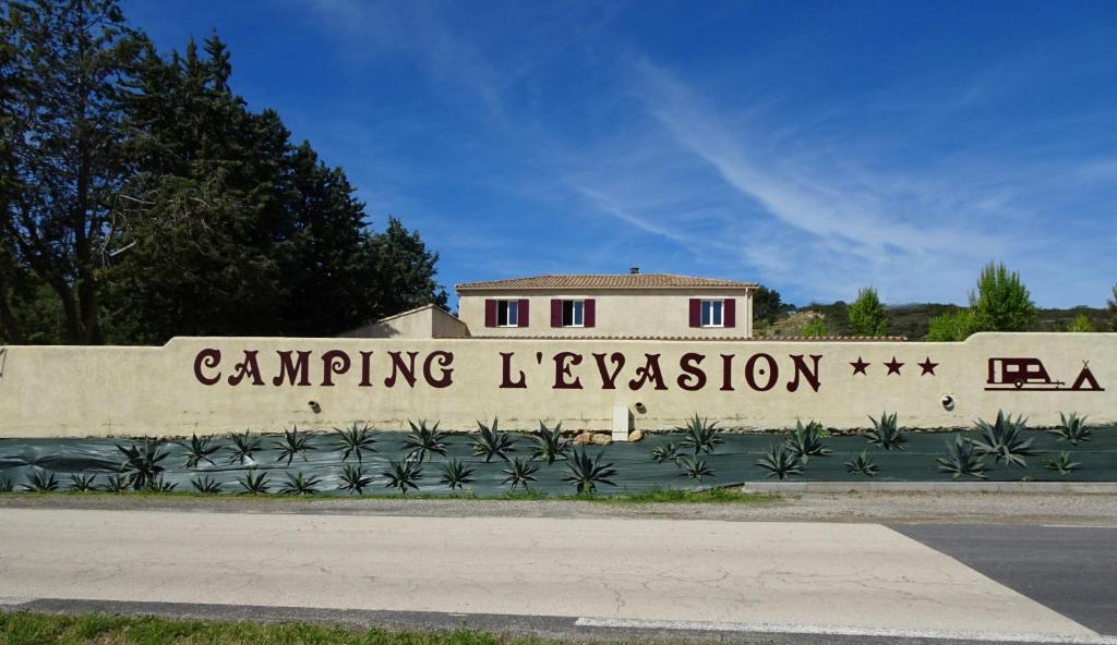 un muro de contención con las palabras acampar la lecesión en él en Camping L'Evasion en Fontès
