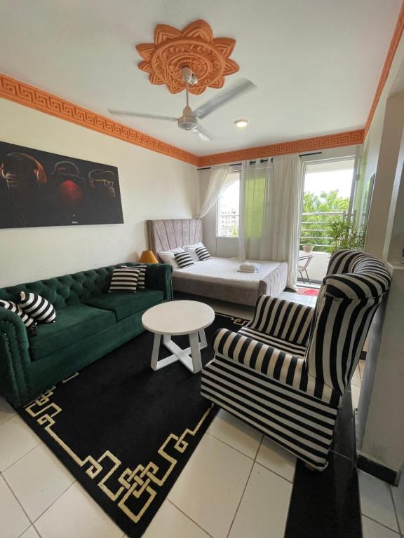 a living room with a green couch and two chairs at bamburi studio in Mombasa