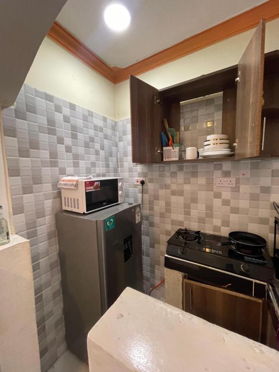 a kitchen with a refrigerator and a microwave at bamburi studio in Mombasa