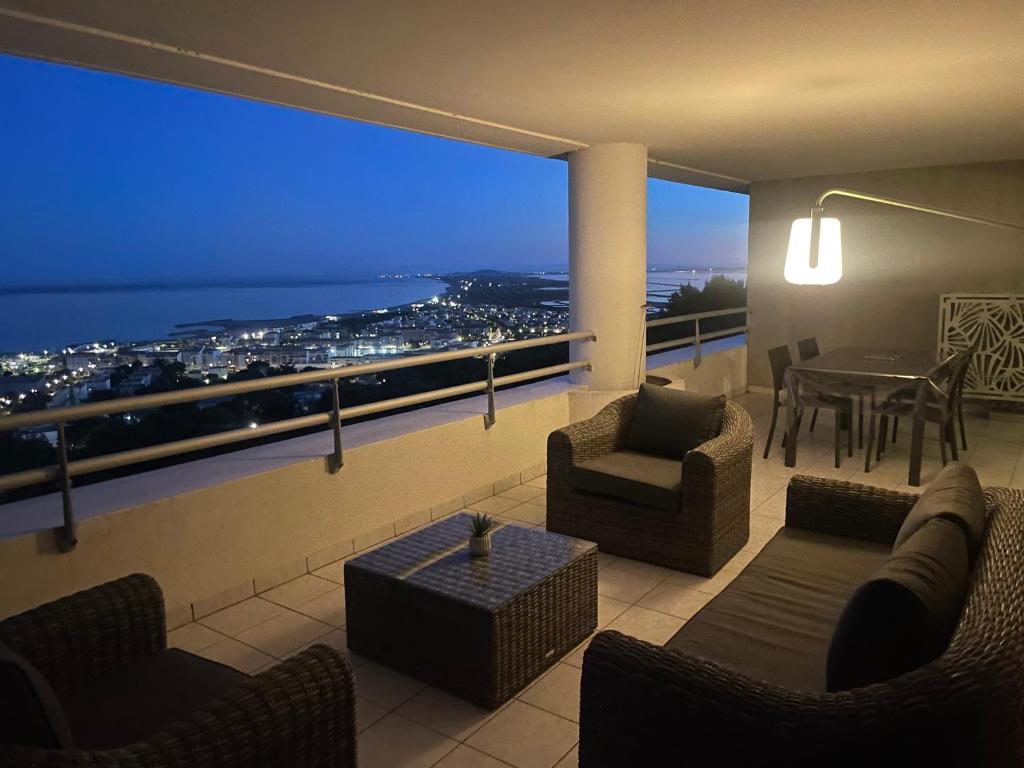 ein Wohnzimmer mit Blick auf eine Stadt bei Nacht in der Unterkunft L'air Marin Clim&Parking in Sète