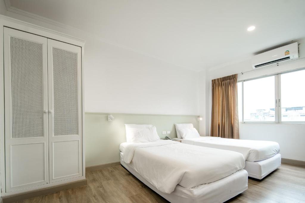 Postel nebo postele na pokoji v ubytování Dhevaraj Hotel