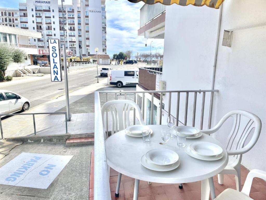 a white table and chairs on a balcony with a street at La Solana in Roses