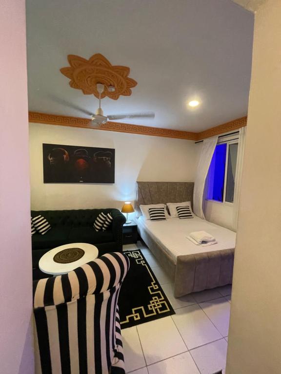 a small room with a bed and a couch at bamburi studio in Mombasa