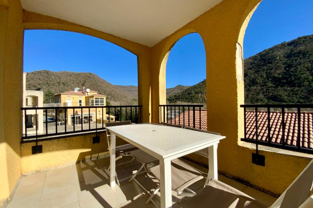 a balcony with a white table and two windows at Les Naïades C12 - 2 bedrooms for 5 people ! in Avène