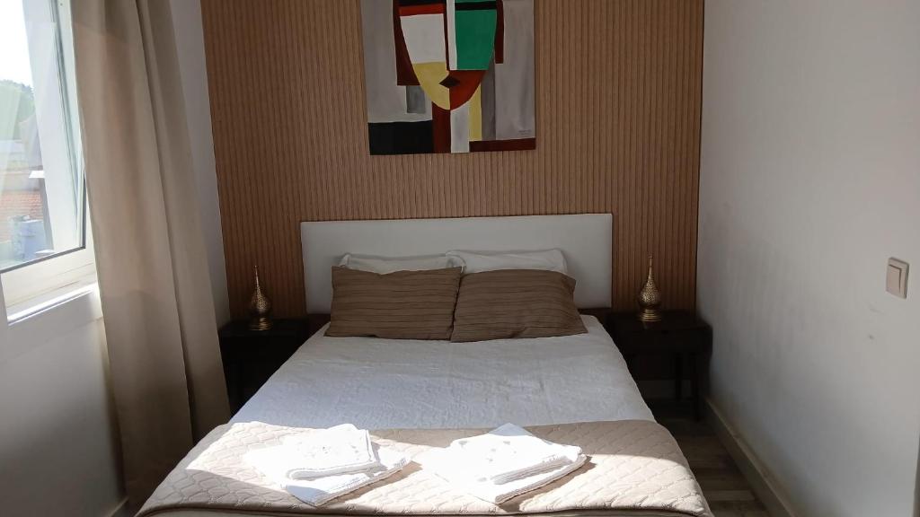 a bedroom with a bed with towels on it at Villa Regio Room in Vila do Conde