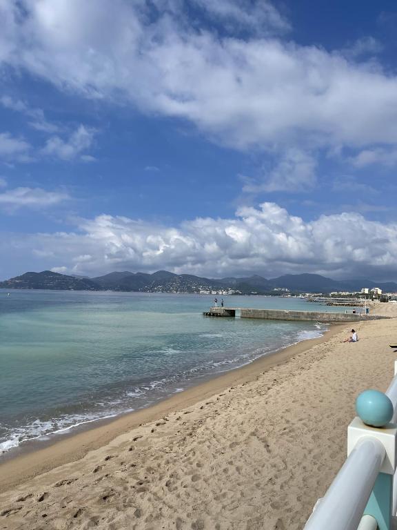 une plage de sable avec une jetée dans l'eau dans l'établissement Cannes Beach Residence vue mer et pisicne, à Cannes