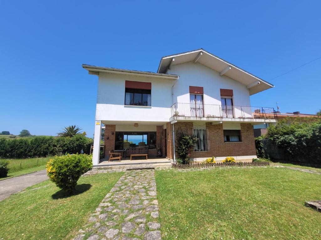 a white house with a balcony and a yard at Tu escapada soñada entre el mar y la montaña! in La Isla