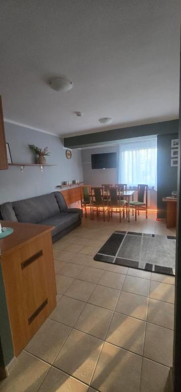 a living room with a couch and a table at Ośrodek Wczasowy Bursztyn in Gdańsk