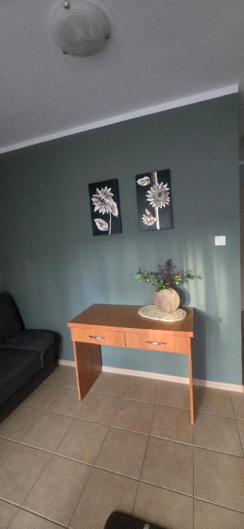 a table in a room with a couch and pictures on the wall at Ośrodek Wczasowy Bursztyn in Gdańsk